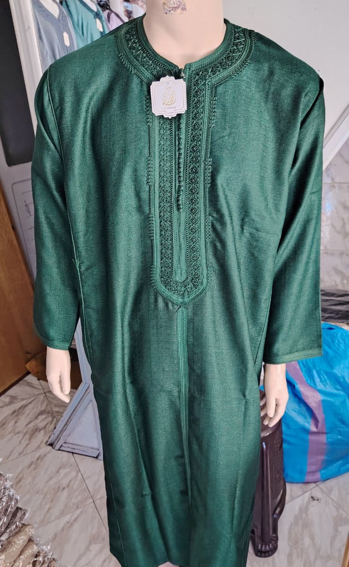 Real photograph of the Emerald embroidered Moroccan thobe, full length on a hanger in the shop in Morocco where my grandfather chooses the pieces.